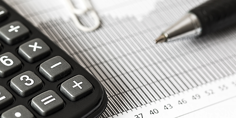 Taxes and paperwork zoomed in on pen and papers.