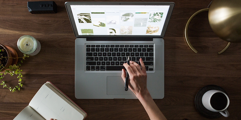 An overhead look at a person working on a no-code design website on a laptop on a desk.