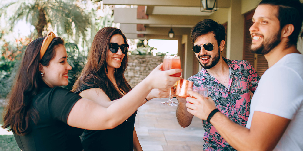 Group of people celebrating and cheers-ing with beverages, an example of unsafe pandemic parties.