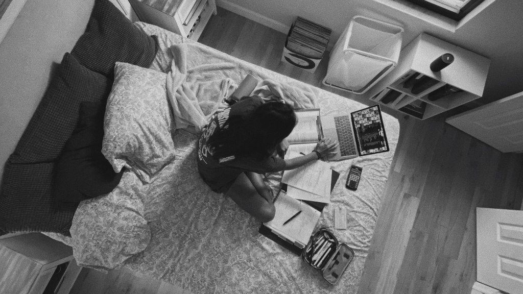 Woman sitting on bed with computer representing need for digital executor