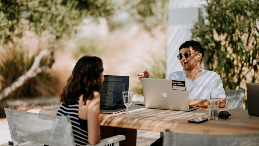 Two real estate works practicing work life balance at a cafe with their laptops