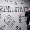 productivity written on wall with man on cellphone.