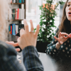 A woman practices ASL (American sign language) with another person, speaking to emphasize what they're saying.