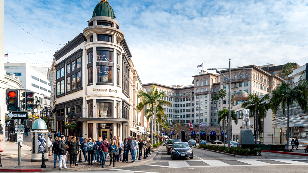 A view of the street in downtown Los Angeles, with pedestrians walking along the crosswalk.