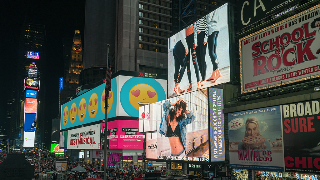 A view of Times Square in New York featuring many glowing billboards and visual advertisements.
