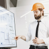 A man in an orange hard hat reviews eminent domain while showing off a schematic for a new building.