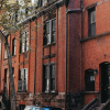 A neighborhood of brick walled apartments and townhomes, with a view from the sidewalk.