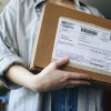 A person holds a package from the UPS mail service.