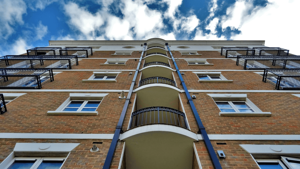 A set of affordable housing apartment buildings, looking up from the ground toward the sky.