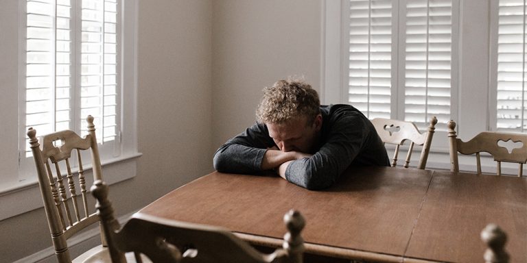 Man sad and alone, representing imposter syndrome.