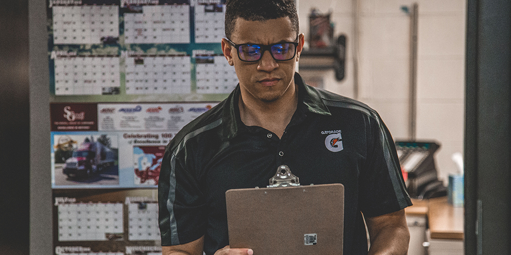 A serious man considers a clipboard in potential employment scams.