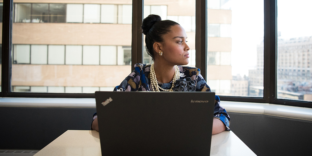 Visa employee on a laptop looking out the window.