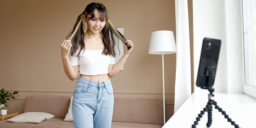 TikTok creator with a phone recording on a stand, but dances can be a sign of cultural appropriation.