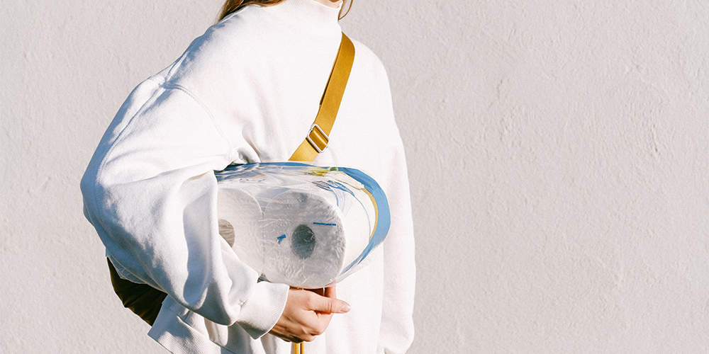 Woman holding a package of toilet paper, affected by inflation.