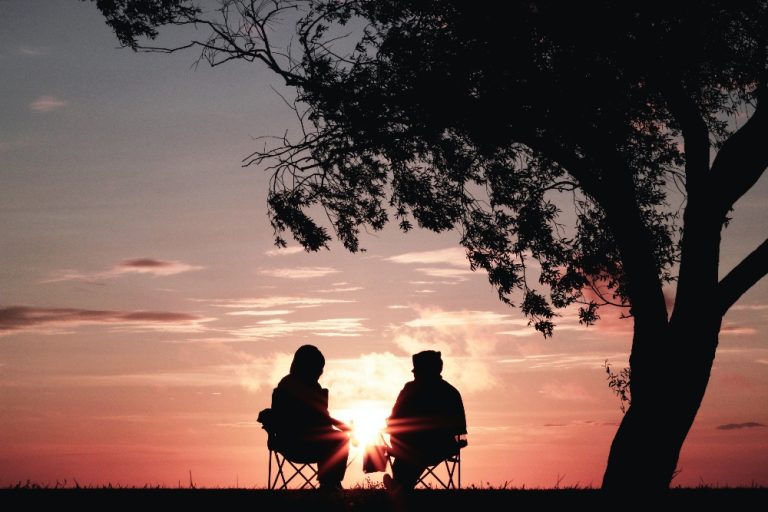 Two silhouettes of people looking out over the sunset to discuss succession planning.