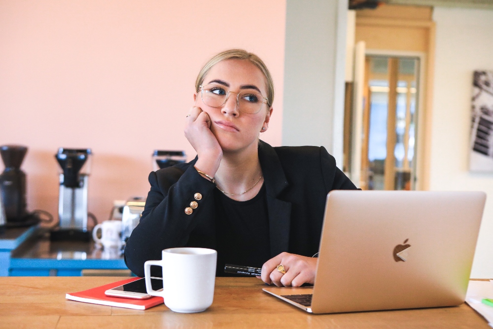 Frustrated job seeker in front of mac computer.