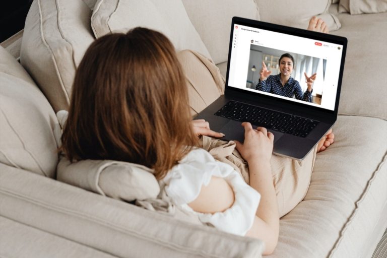 Woman looking at ZipMessage messaging tool on her laptop on couch.