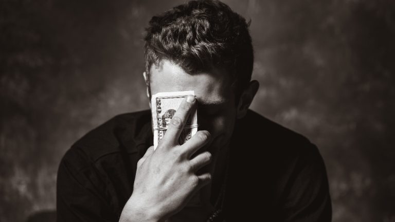 Person holding money representing career passion without stable income.