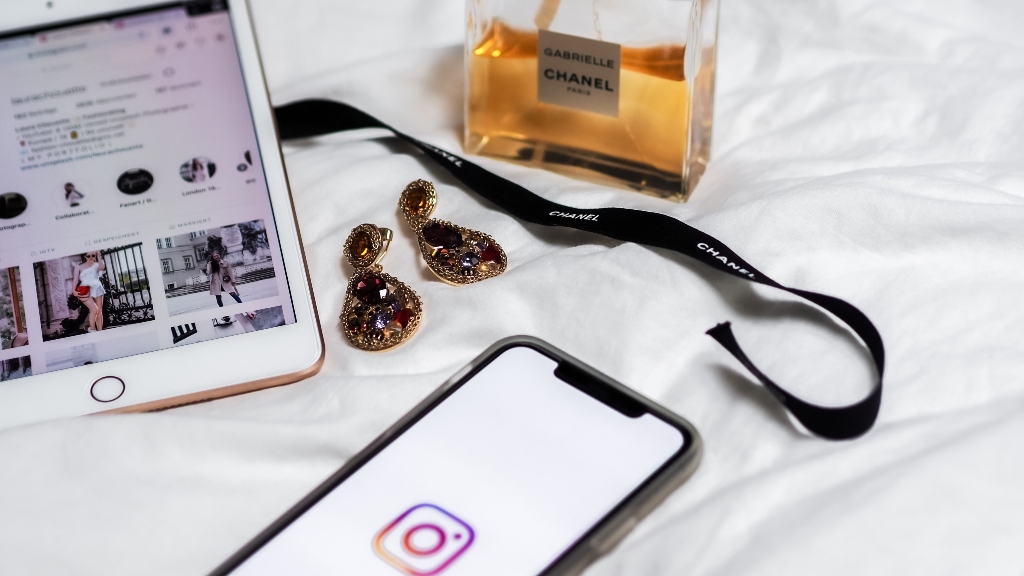 instagram on phone and ipad with earrings and perfume representing kim k crypto promotion instagram on phone and ipad with earrings and perfume representing kim k crypto promotion