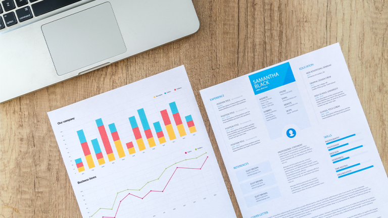 Two analysis documents sit on a desk next to a laptop keyboard.